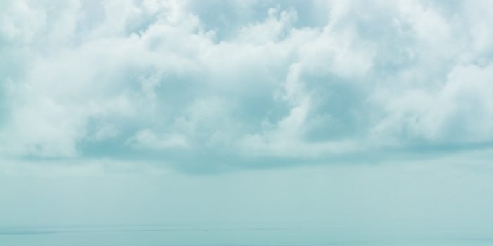 Fluffy clouds hovering above the sea.