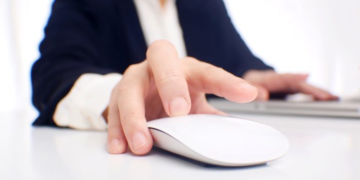A man's hand on a computer mouse.
