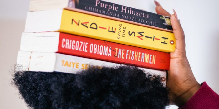 Woman carrying four novels on her head.