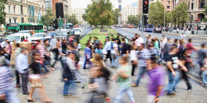 Timelapse image of people crossing a busy street.